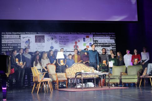 Gruppenfoto der Preisträger:innen auf der großen Bühne