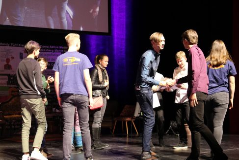 Der Moderator gratuliert den Preisträger:innen