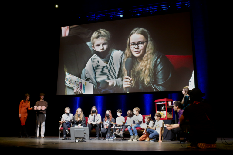Gewinner*innen Kategorie Schule macht Medien mit Leinwand im Hintergrund.